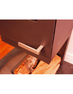 stufa a legna Skantherm Pico in acciaio grigio antracite. Design con particolare cura dei dettagli. Design minimalista. Maniglia squadrata in acciaio inossidabile opaco che ripete il design della stufa . Piedistallo in acciaio.